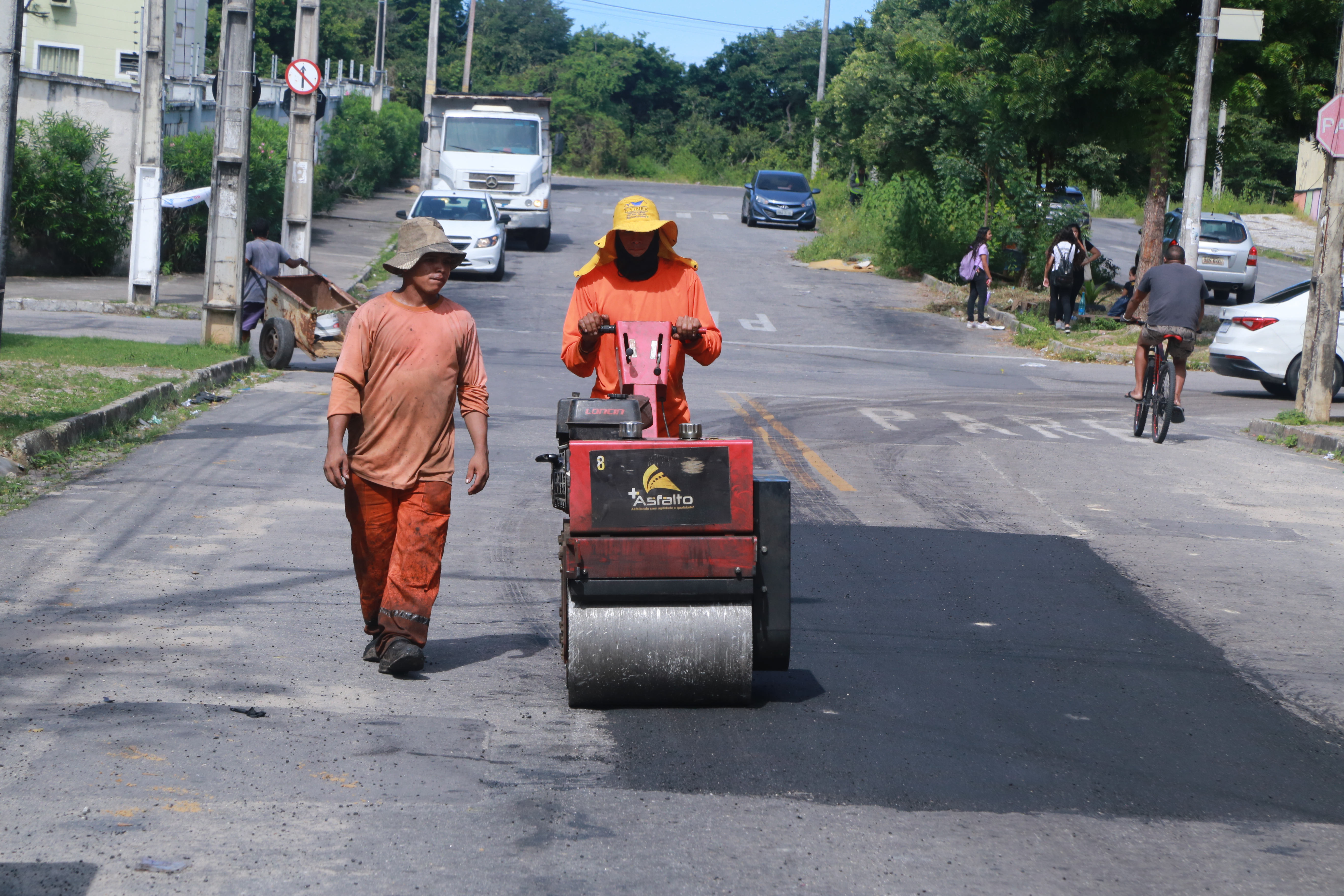 homens asfaltando uma via